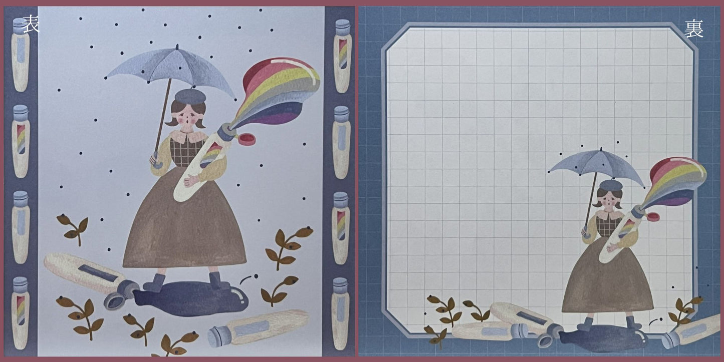 鉛筆に囲まれた森の中で読書する少女が描かれた、伊野あゆみさんの両面ましかくメモ。
A double-sided square memo pad by Ayumi Ino, featuring a girl reading among pencil trees in a forest-like scene.