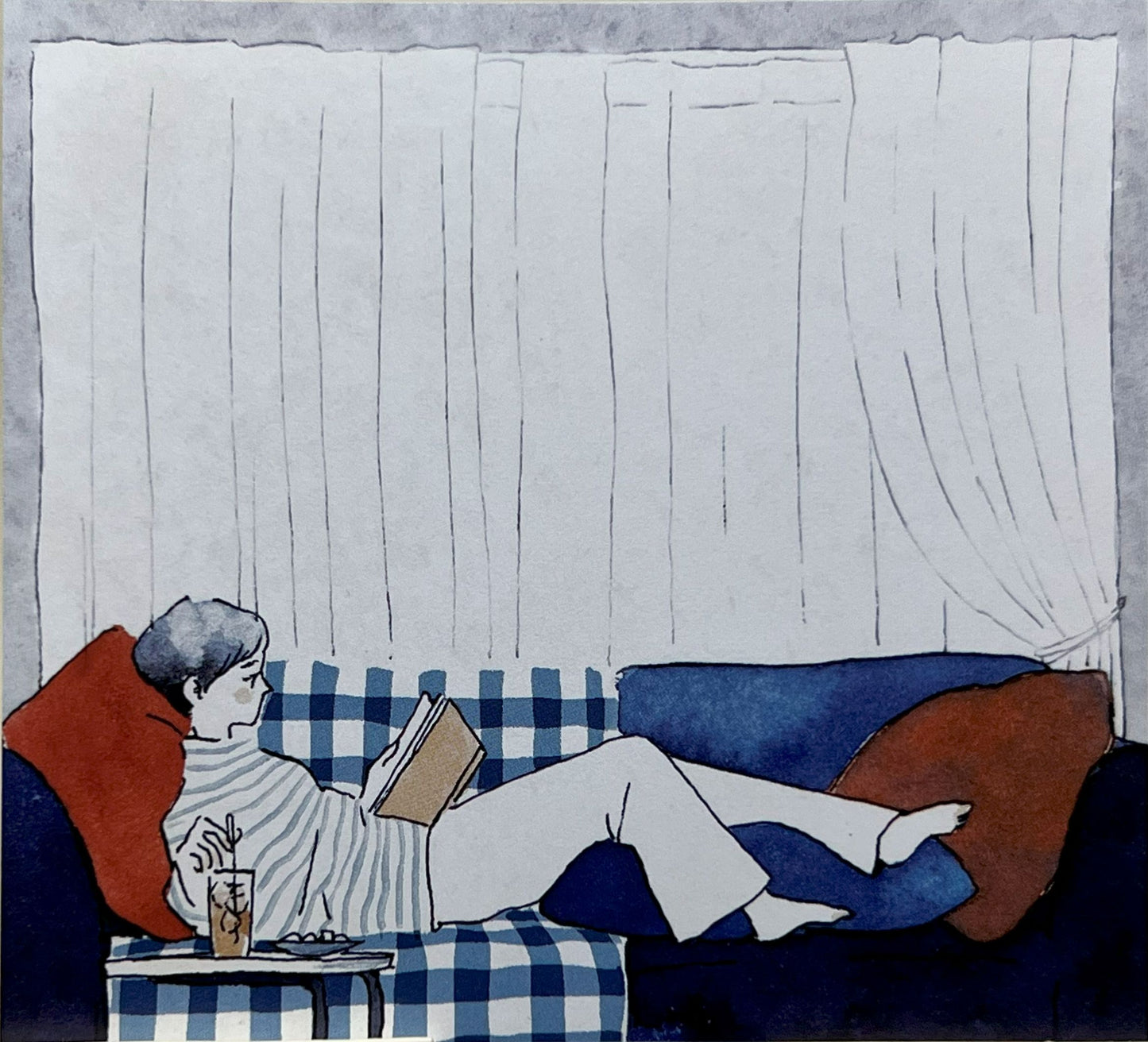 ソファで読書しながらくつろぐ人とアイスティー
Person reading on a sofa with iced tea and cushions